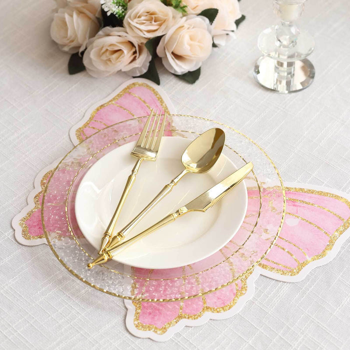 Gold cutlery set on a decorative butterfly placemat with a white plate.