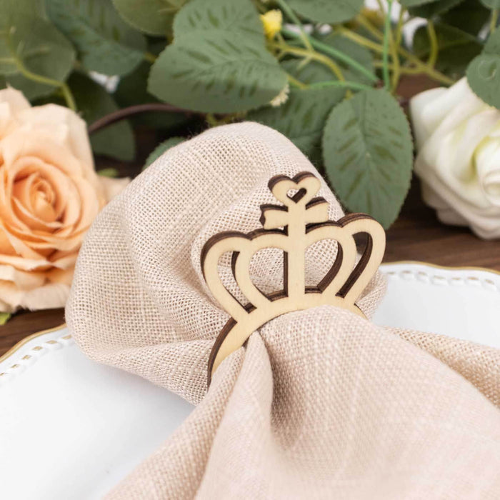 Wooden crown napkin holder with beige linen napkin and floral backdrop.