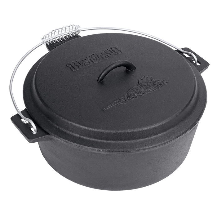 A black cast iron chicken fryer with a domed lid and coiled wire handle on a white background