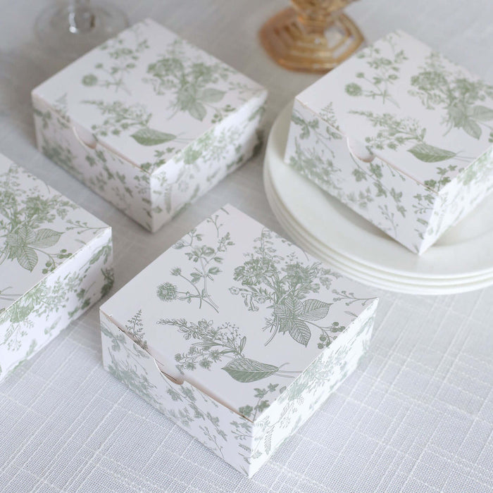 Decorative floral gift boxes on a textured tablecloth.
