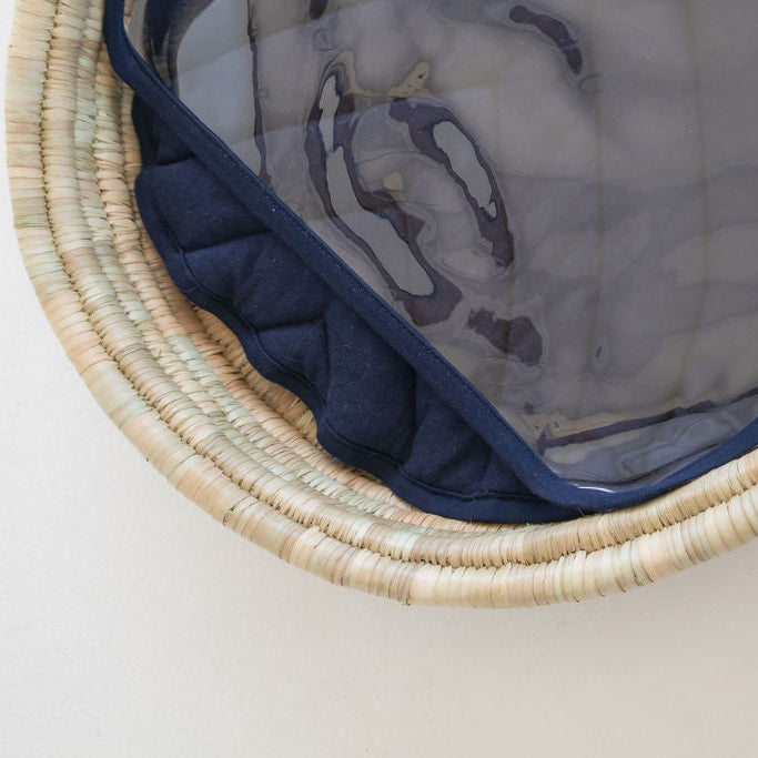 Close-up of a woven basket with a blue interior on a light background