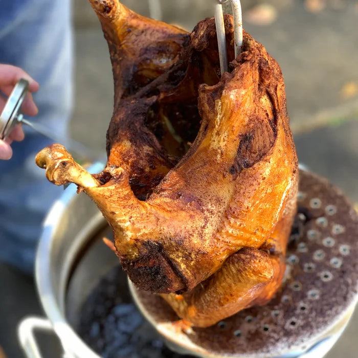 Fried Turkey on a poultry rack coming out of a turkey fryer