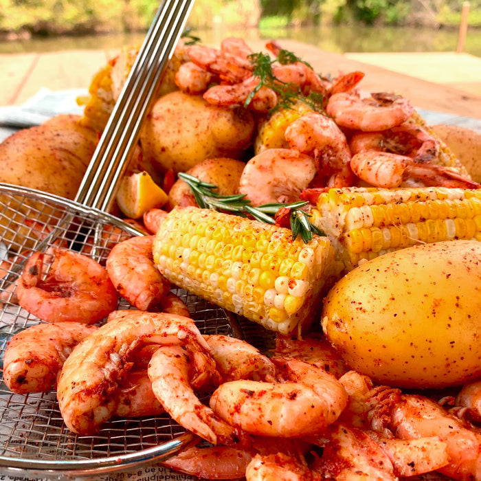Boiled shrimp with corn and potatoes with mesh skimmer outside