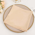 Beige napkin neatly folded on a decorative plate.