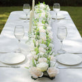 Elegant floral table centerpiece with candles and glassware for a dining setting.