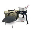 A camper's combo kit including a black steel frame cooker, aluminum fry pot and basket, cast iron discada, and gear bag on a white background