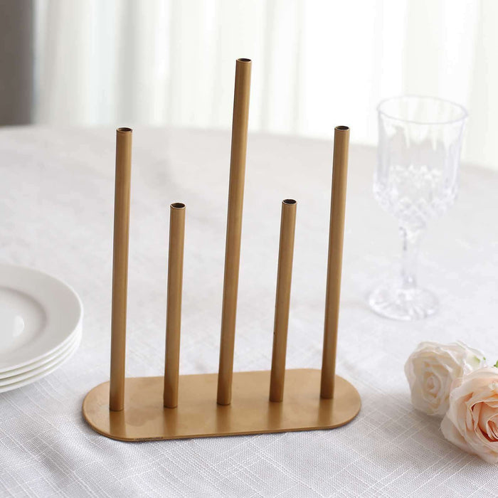 Gold flower vase holder with five tubes on a table setting.