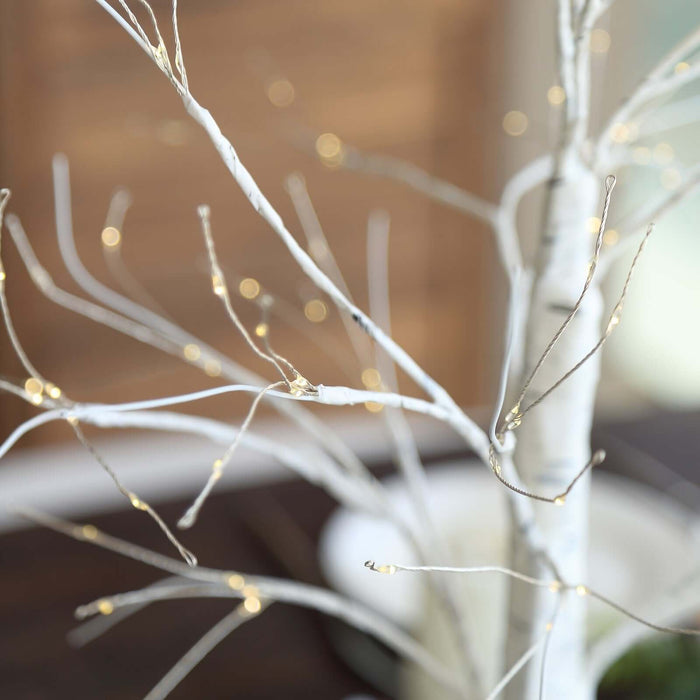 White decorative tree branches with warm LED lights.