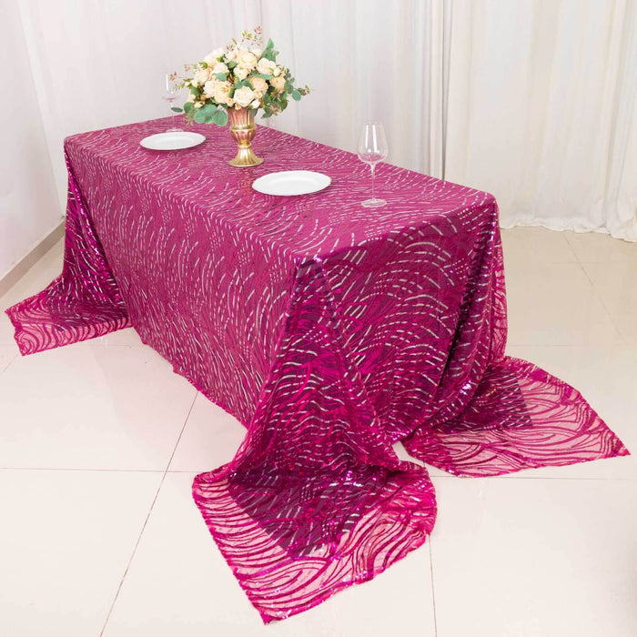 Elegant pink tablecloth with a wave pattern draped over a table set for dining.