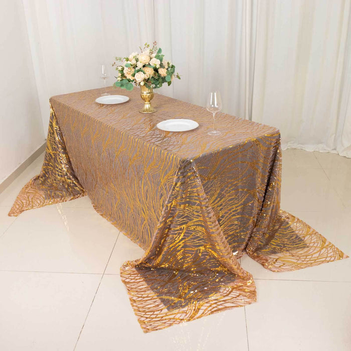 Elegant gold and brown tablecloth on a dining table with floral centerpiece.
