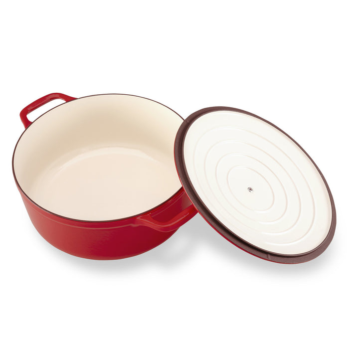 Red enameled cast iron Dutch oven with a white interior on a white background