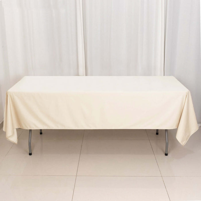 Beige tablecloth draped over a folding table in a studio setting.