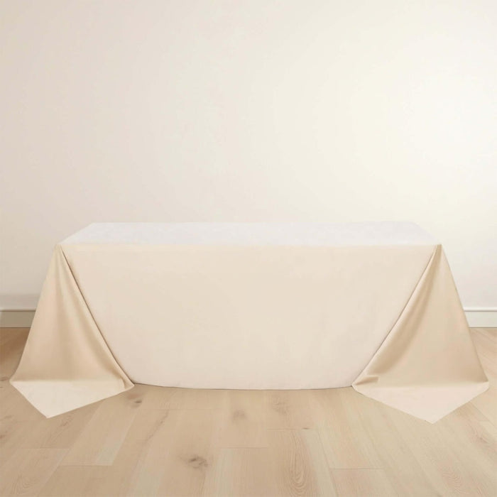 Beige tablecloth draped over a table with elegant folds.