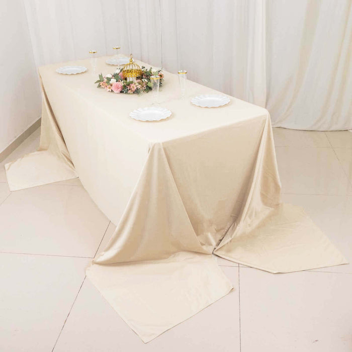Elegant beige tablecloth draped over a table with floral centerpiece.