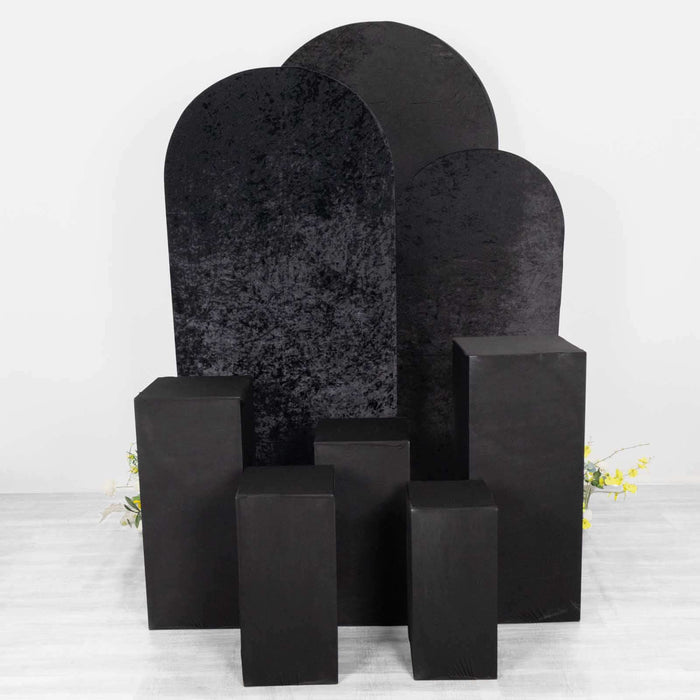 Black display pedestals and backdrop in various shapes for showcasing products.