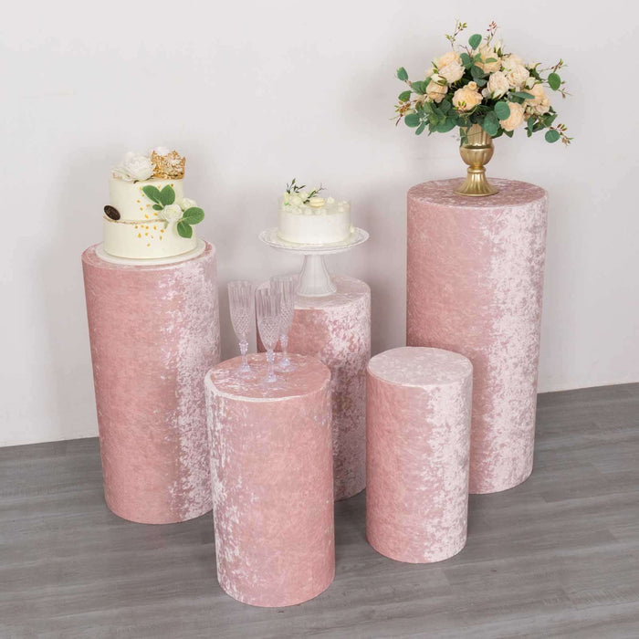 Pink velvet display pedestals with floral arrangement and cake on top.