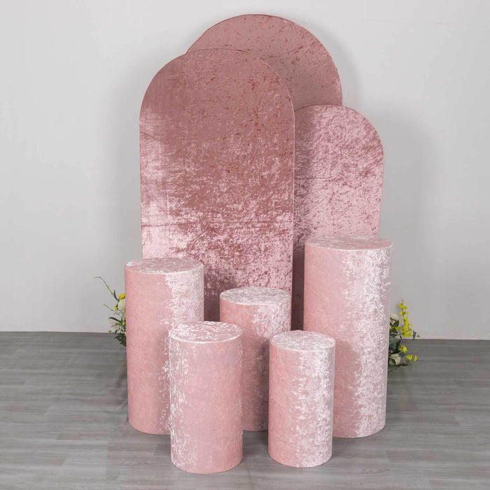 Pink velvet display pedestals in various sizes against a plain backdrop.