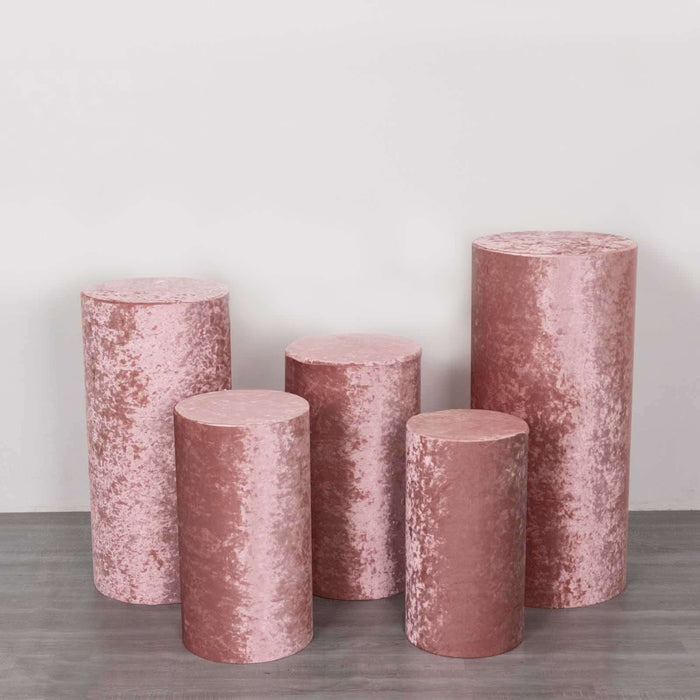 Pink velvet pedestals in various heights on a plain background.