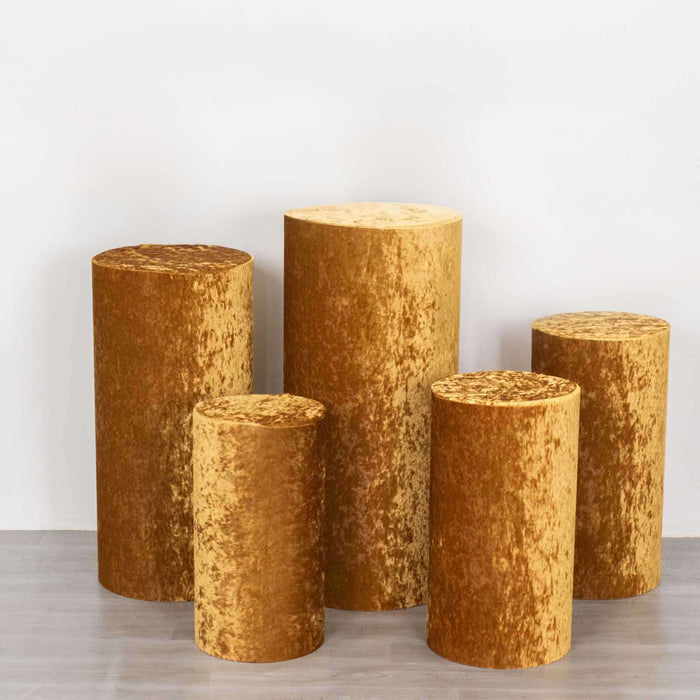 Set of five golden velvet pedestals in various heights