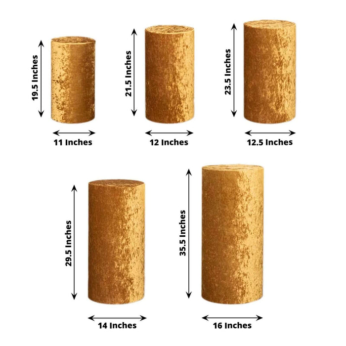 Set of five gold pillar candles in various heights and sizes, displayed on a white background.