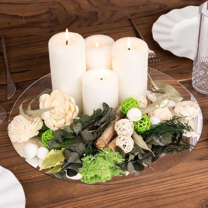 Decorative candle centerpiece with greenery and floral accents.
