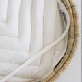Close-up of a clear changing mat on top of a changing padding in a lala palm changing basket on a plain background