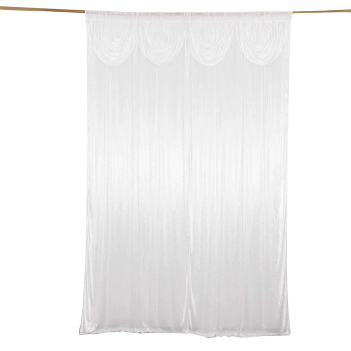 White sheer curtain with pleated design hanging in a studio setting.